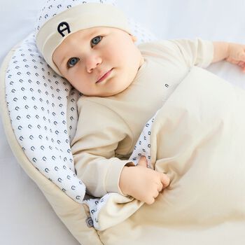 عش أطفال بشعار باللون بيج وأبيض